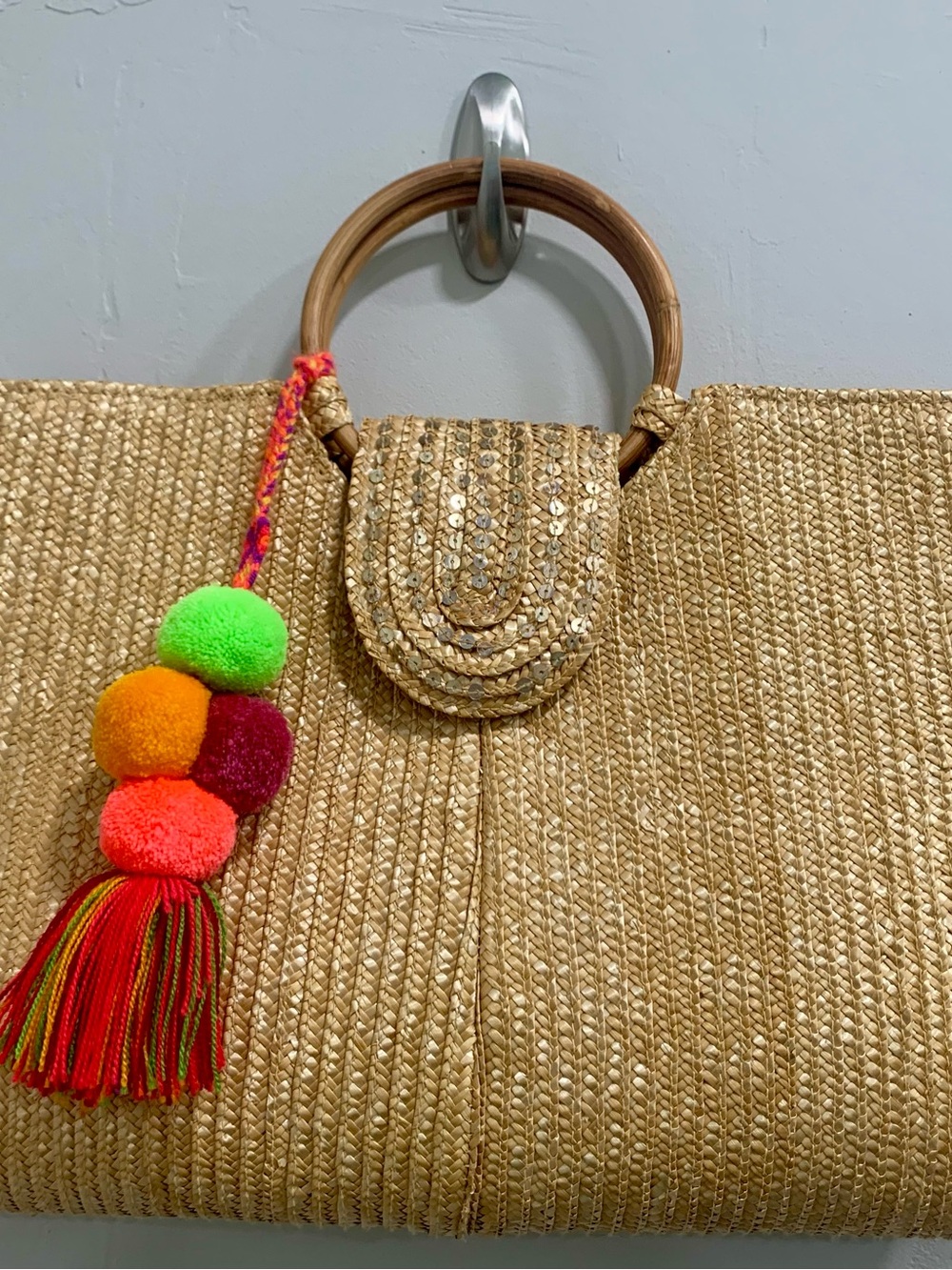 Summer straw handbag with brights striped lining and gun pompon charm.